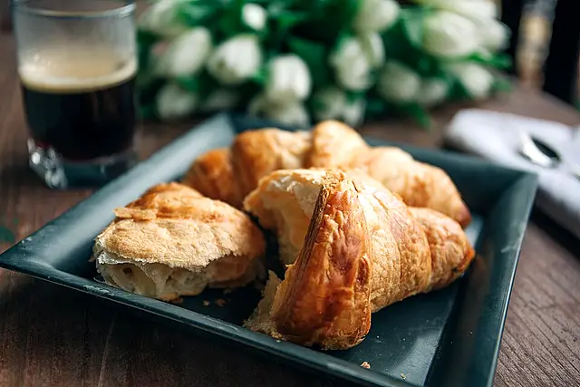 Espresso and a butter croissant on a wooden table